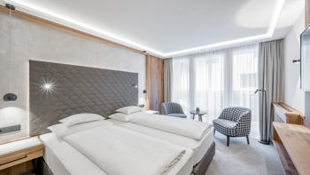 One of the Hotel's bedrooms, with a clean presentation and view of the mountains from it's windows.