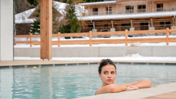 A view of the outdoor pool with a backdrop of the stunning Dolomite mountains