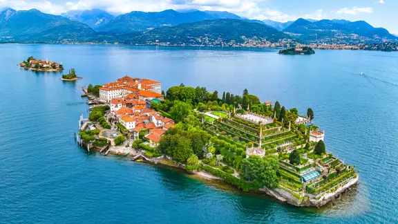 cenic view of Isola Bella on Lake Maggiore, showcasing the island’s ornate gardens and historic palazzo surrounded by blue lake waters and distant mountains.