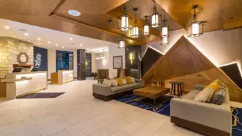 The lobby of Delta Whistler Village Suites in Whistler, featuring modern mountain decor with cosy seating areas and warm ambient lighting.