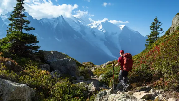Solo hiker crossing rugged rocky terrain in the Chamonix mountains under a clear sky