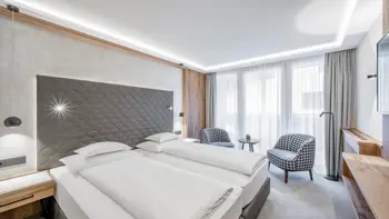 One of the Hotel's bedrooms, with a clean presentation and view of the mountains from it's windows.