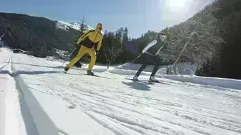 Two skiers swiftly descend a mountain slope, carving through fresh powdered snow.